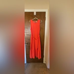 Coral, sleeveless dress with fabric belt.